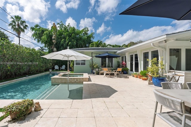 view of pool featuring a patio, a pool with connected hot tub, and outdoor dining space