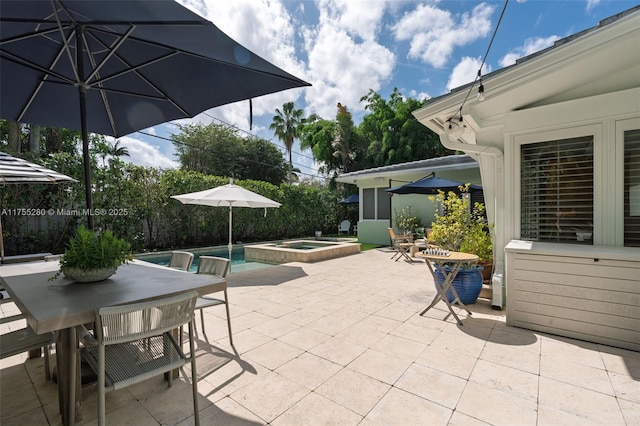 view of patio with a pool with connected hot tub, outdoor dining space, and an outbuilding