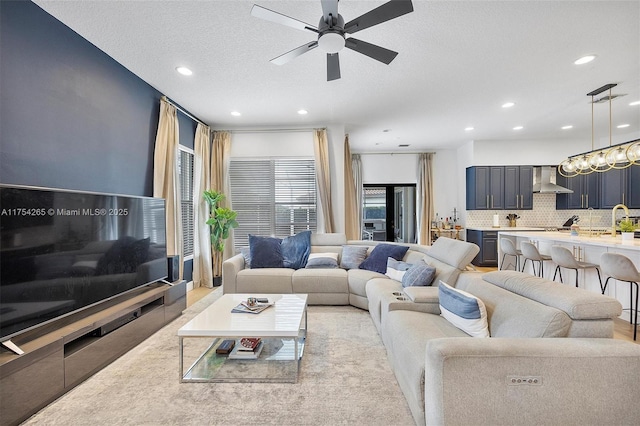 living area with a textured ceiling, a ceiling fan, and recessed lighting