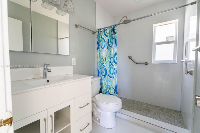 full bathroom with toilet, vanity, and a tile shower