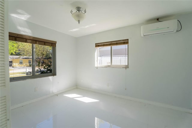 unfurnished room with an AC wall unit and baseboards