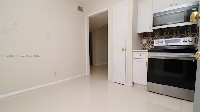 kitchen featuring white cabinets, tasteful backsplash, visible vents, and stainless steel appliances