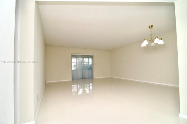 empty room with an inviting chandelier, tile patterned flooring, and baseboards