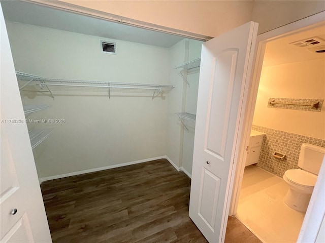 walk in closet featuring visible vents and wood finished floors