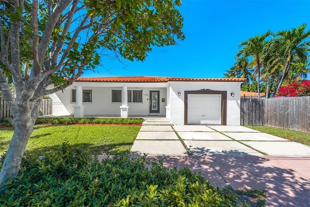 mediterranean / spanish home with concrete driveway, stucco siding, a tile roof, a garage, and fence