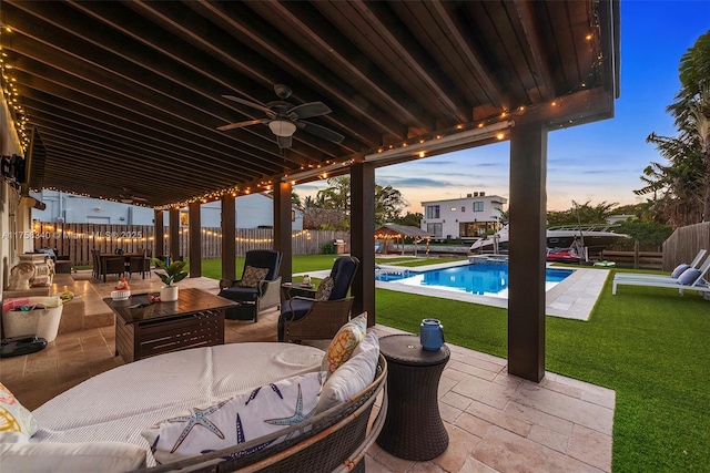 patio terrace at dusk with a fenced backyard, a fenced in pool, and a lawn