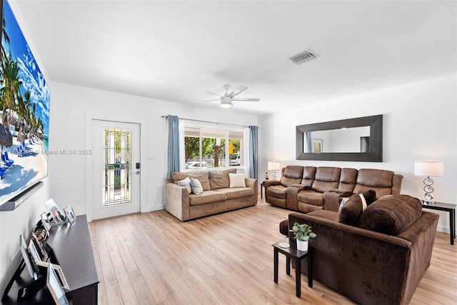 living area with light wood-style floors, visible vents, and a ceiling fan