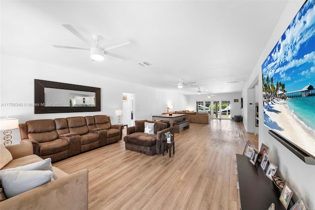 living room featuring light wood finished floors, ceiling fan, and visible vents