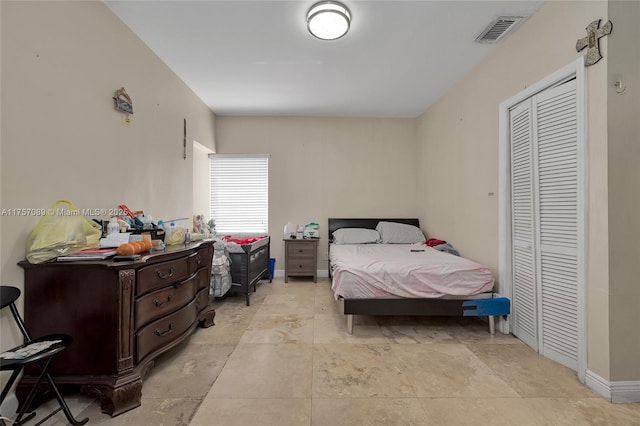 bedroom with a closet, visible vents, and baseboards