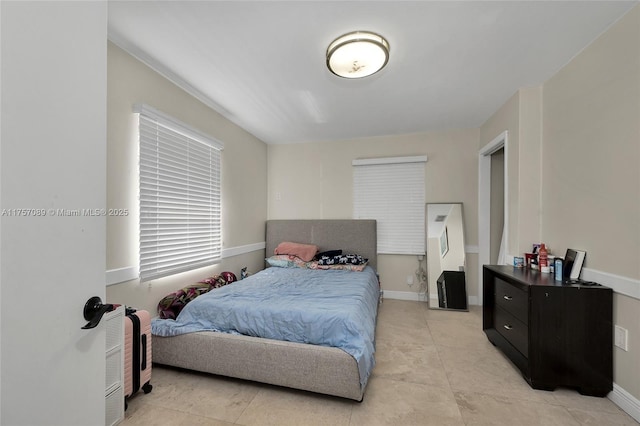 bedroom featuring baseboards and light tile patterned floors