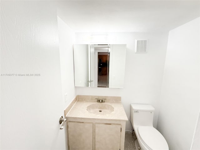 half bath with vanity, toilet, and visible vents