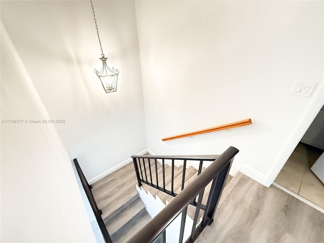 staircase featuring baseboards and wood finished floors