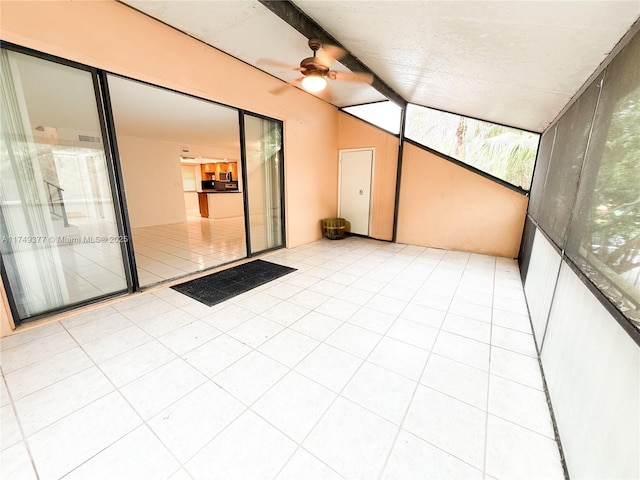 unfurnished sunroom featuring a ceiling fan and vaulted ceiling