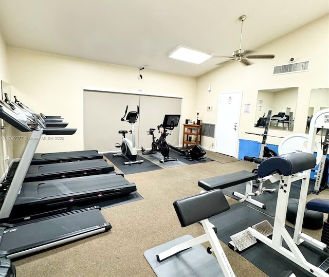 gym featuring vaulted ceiling, a ceiling fan, and visible vents