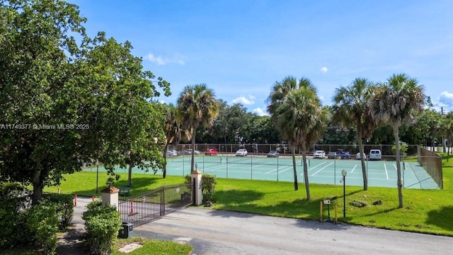 view of sport court featuring a yard and fence