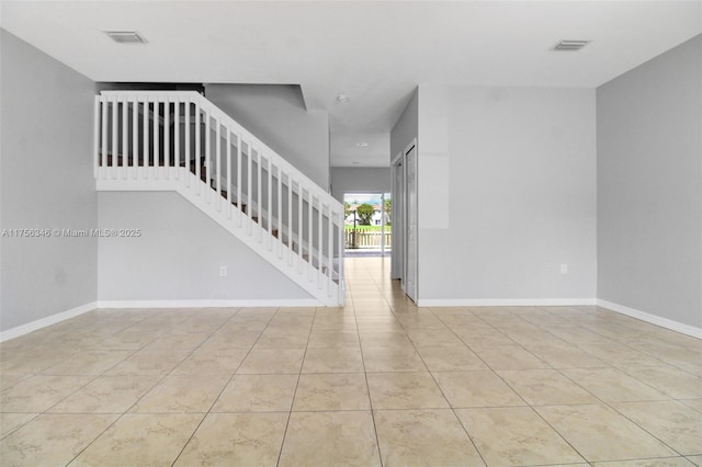 spare room with visible vents, stairs, and baseboards