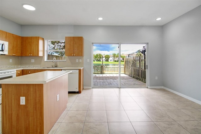 kitchen featuring light countertops, white appliances, plenty of natural light, and decorative backsplash