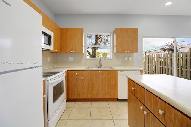 kitchen with white appliances, light tile patterned floors, light countertops, and a sink