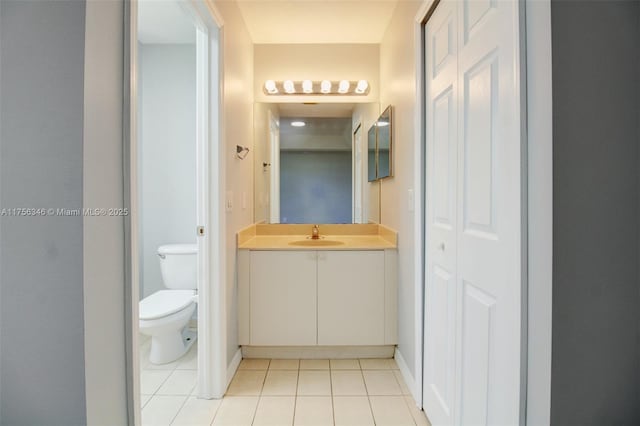 bathroom with baseboards, vanity, toilet, and tile patterned floors