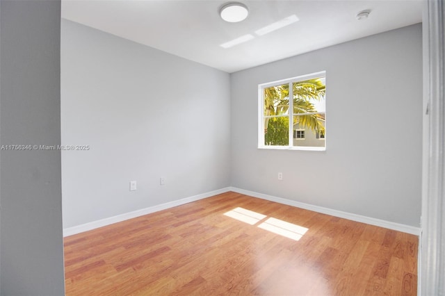 unfurnished room with baseboards and wood finished floors