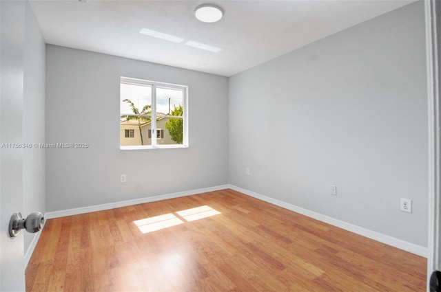 empty room featuring baseboards and wood finished floors