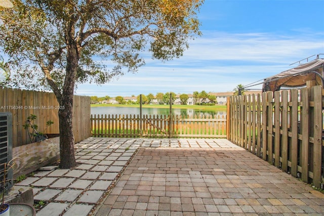 view of patio with a water view and a fenced backyard