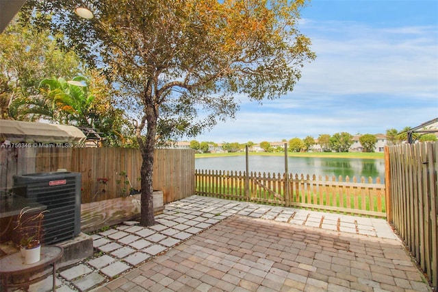 view of patio / terrace with central AC, a water view, and fence