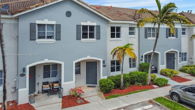 view of property featuring stucco siding and a tiled roof