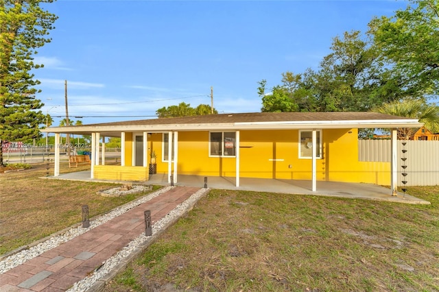 single story home with a front lawn and fence