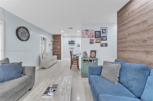 living room featuring wood walls, recessed lighting, visible vents, and baseboards