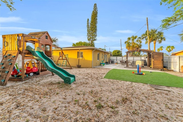 view of playground featuring fence and a patio