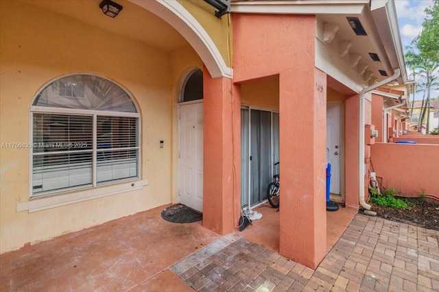 doorway to property featuring stucco siding