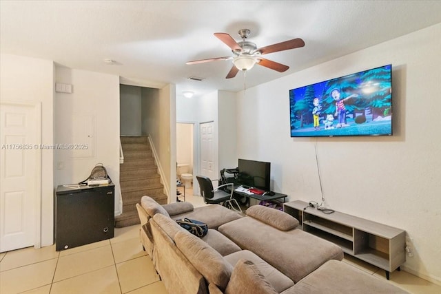 living area with light tile patterned floors, visible vents, stairway, and a ceiling fan