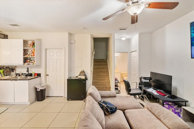 living room with light tile patterned floors, stairs, visible vents, and a ceiling fan