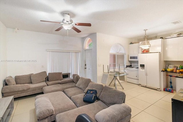 living area featuring light tile patterned floors, visible vents, and a ceiling fan