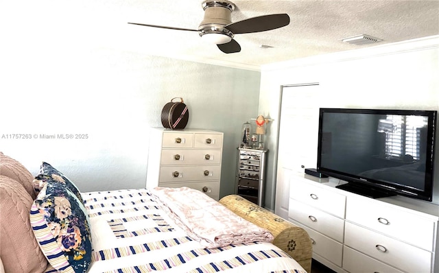 bedroom featuring a textured ceiling, visible vents, a ceiling fan, and ornamental molding