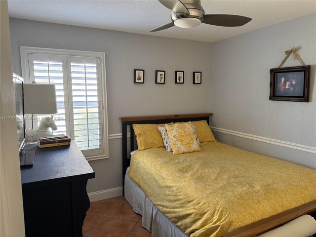 bedroom with baseboards, tile patterned flooring, and a ceiling fan