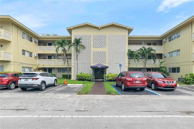 view of building exterior with uncovered parking and central air condition unit