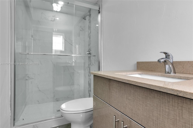 bathroom with toilet, a marble finish shower, and vanity