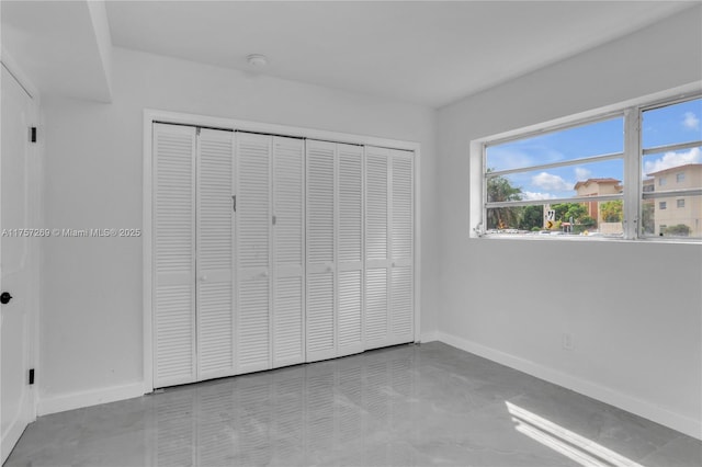 unfurnished bedroom with a closet and baseboards