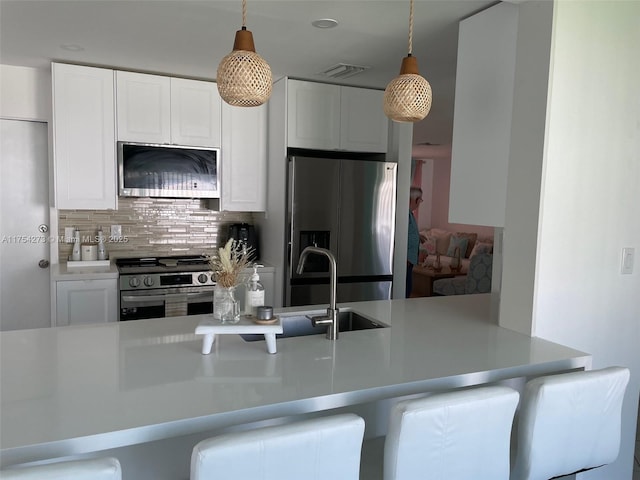 kitchen featuring white cabinetry, tasteful backsplash, visible vents, and stainless steel appliances