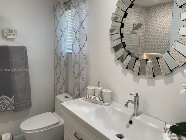 full bath with tiled shower, vanity, and toilet