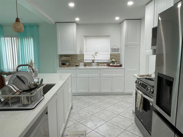 kitchen featuring recessed lighting, white cabinetry, light countertops, appliances with stainless steel finishes, and tasteful backsplash