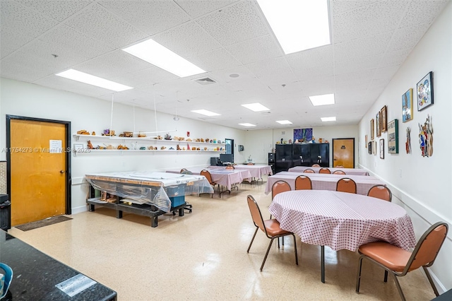 dining space with a paneled ceiling, baseboards, and visible vents