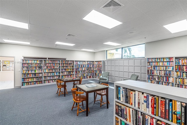 office with bookshelves, a paneled ceiling, carpet, and visible vents