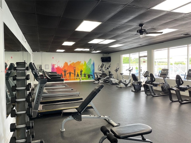 exercise room featuring ceiling fan, a drop ceiling, and visible vents