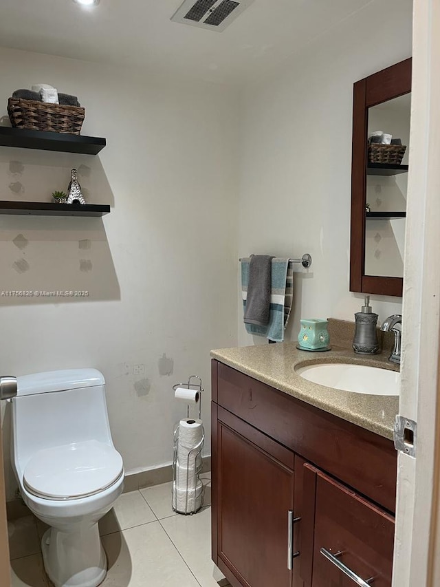 half bathroom with baseboards, visible vents, toilet, tile patterned floors, and vanity