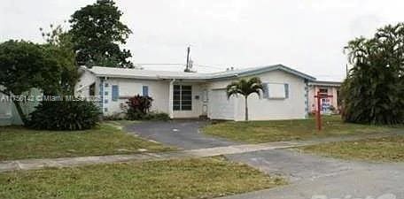 ranch-style home featuring a front yard and driveway