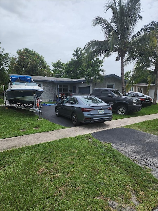 view of front of house featuring a front lawn and aphalt driveway