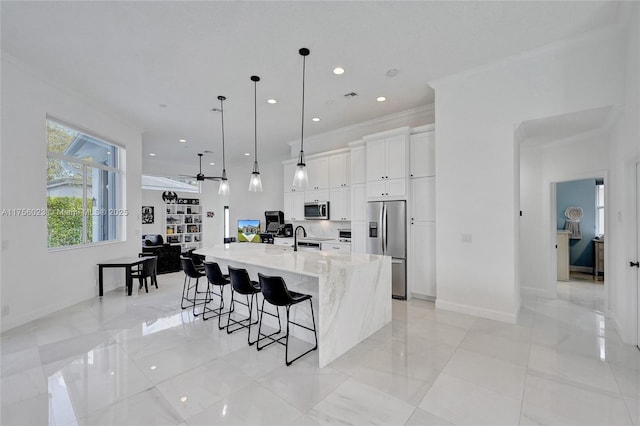 kitchen featuring a kitchen breakfast bar, white cabinets, appliances with stainless steel finishes, a large island, and light stone countertops